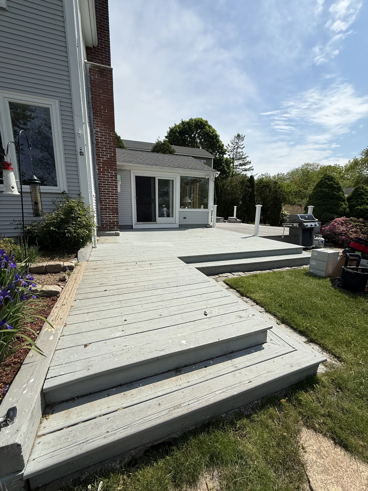Before: the same deck with weathered blue paint and exposed wood